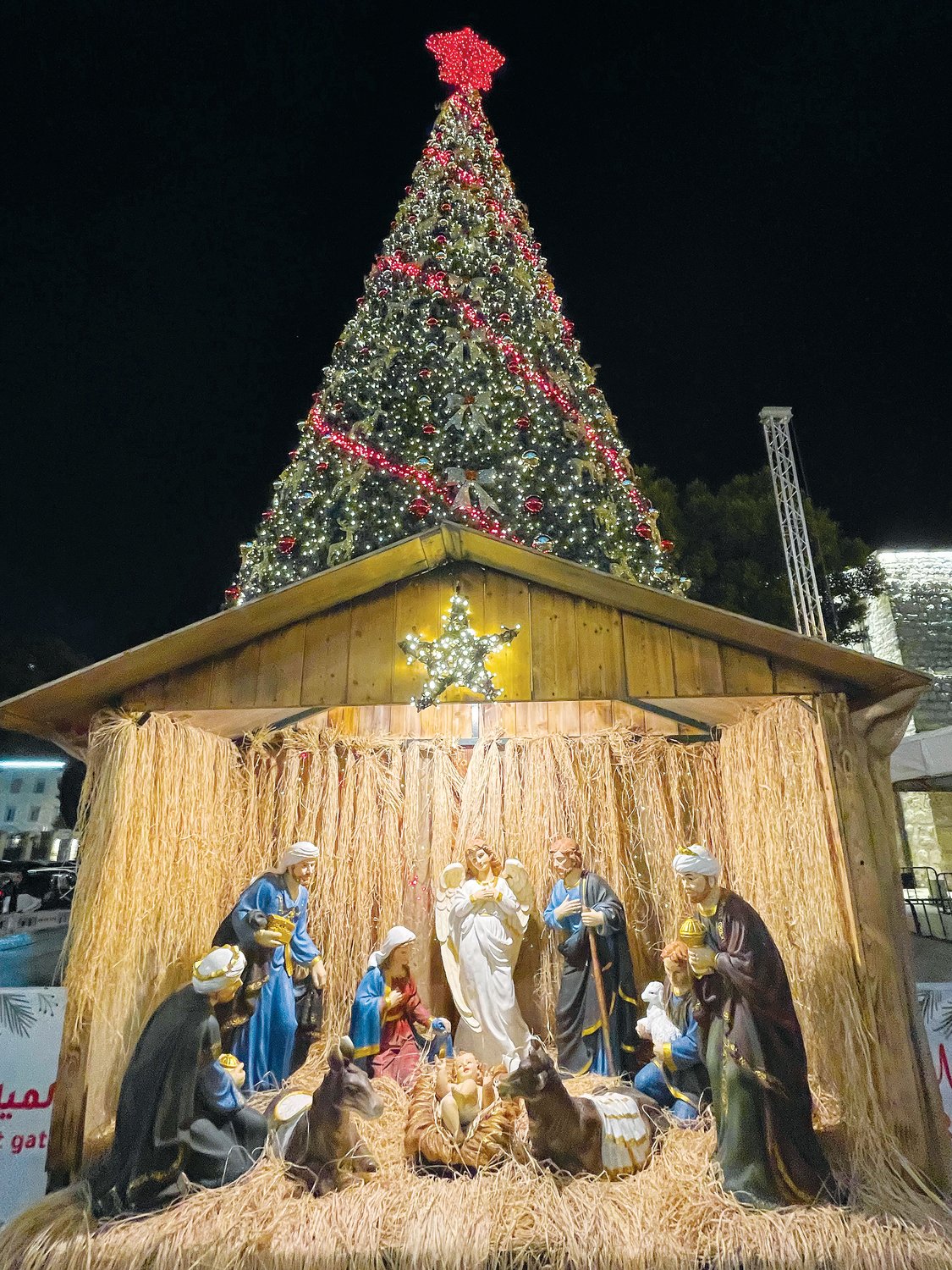 A 36-foot-tall illuminated and brilliantly decorated Christmas tree adorned with a red star serves as the focal point in Manger Square in Bethlehem.